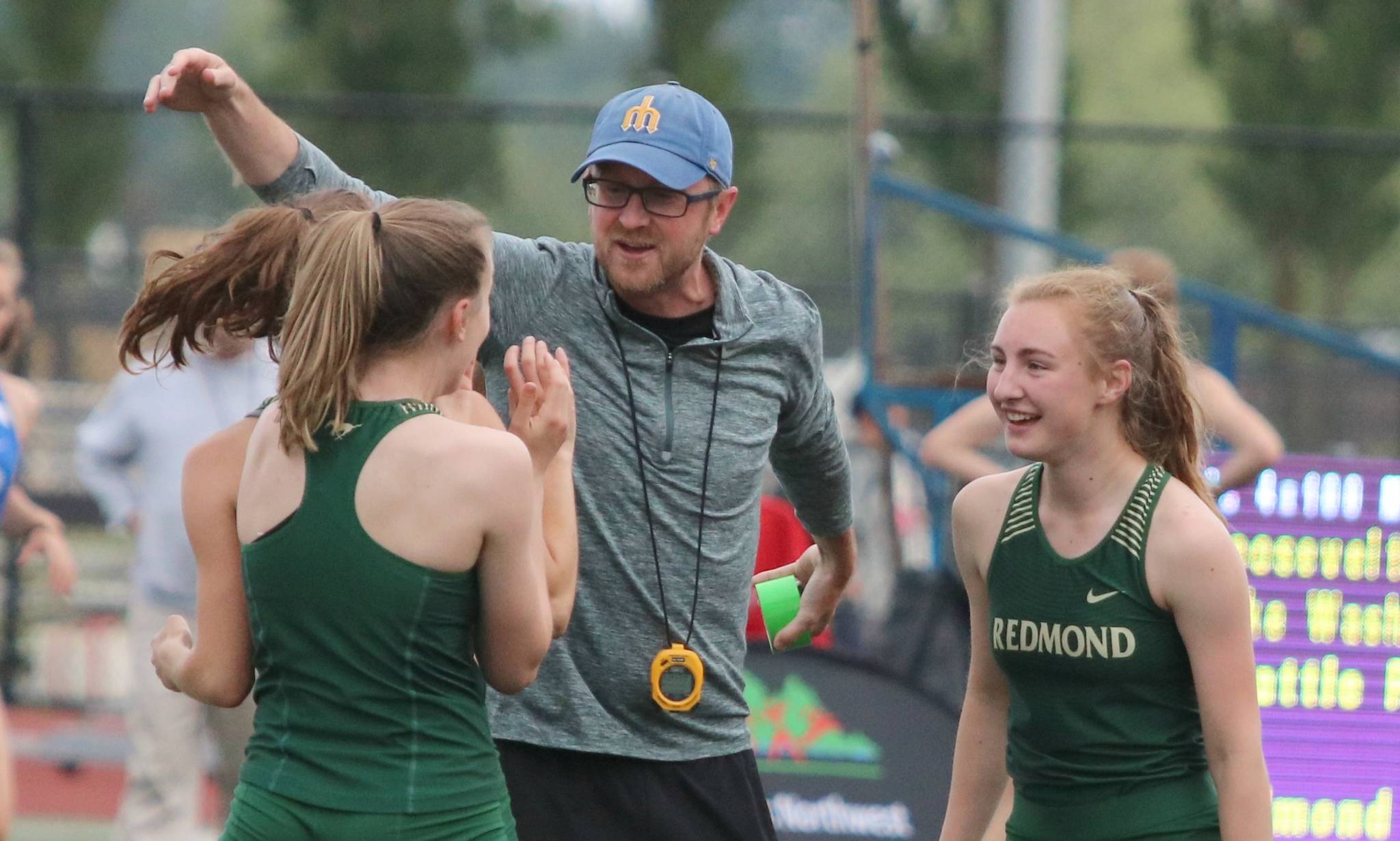 Redmond coach Pete Whitmore congratulates some of his 4x100 relayers after they qualified for state on Friday at the 3A District 2 championships at the Southwest Athletic Complex in West Seattle. Andy Nystrom / staff photo