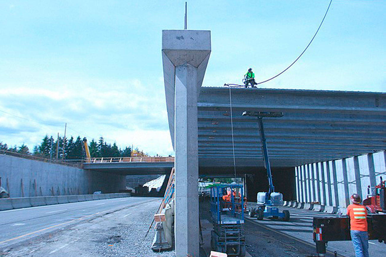 Workers install girders as part of a previous project in 2012 along westbound SR 520. Reporter File Photo