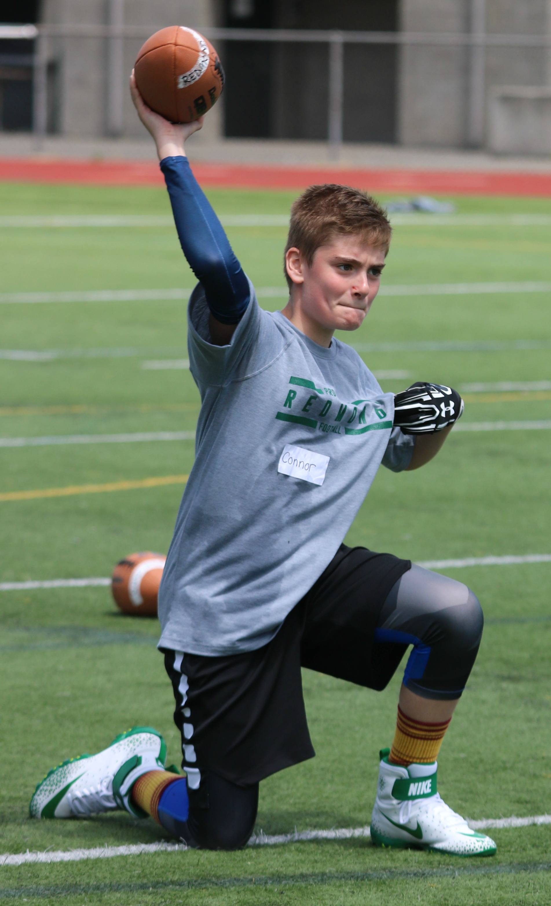 Connor Flynn gets in some passing at the Redmond Junior Mustang Football Camp on June 26. Andy Nystrom / staff photo