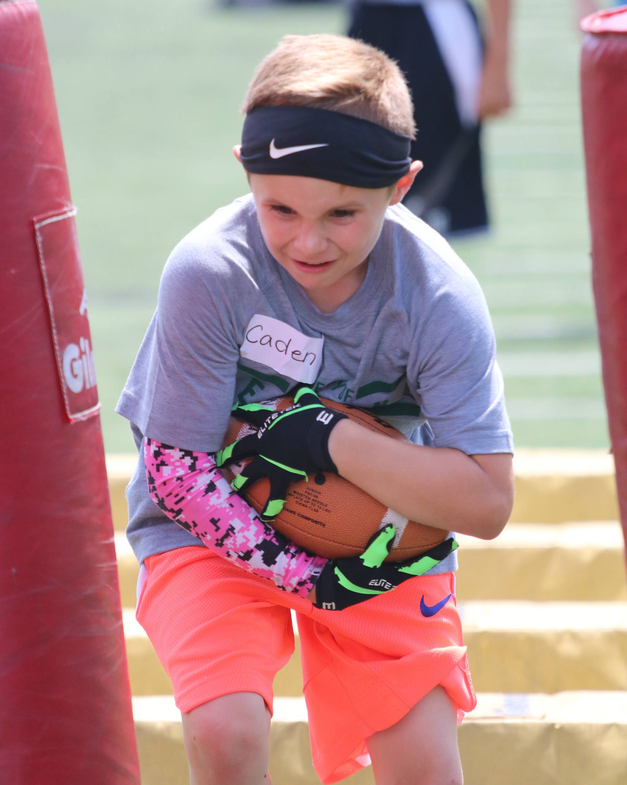 Caden Weber plows through the pads during the Redmond Junior Mustang Football Camp on June 26. Andy Nystrom / staff photo