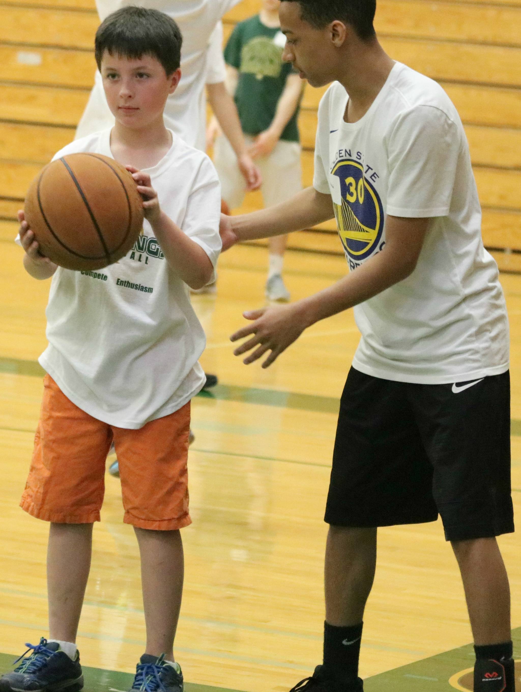 Redmond High player Malakai James, right, shows Ethan Gormley the ropes at last week’s camp. Andy Nystrom / staff photo