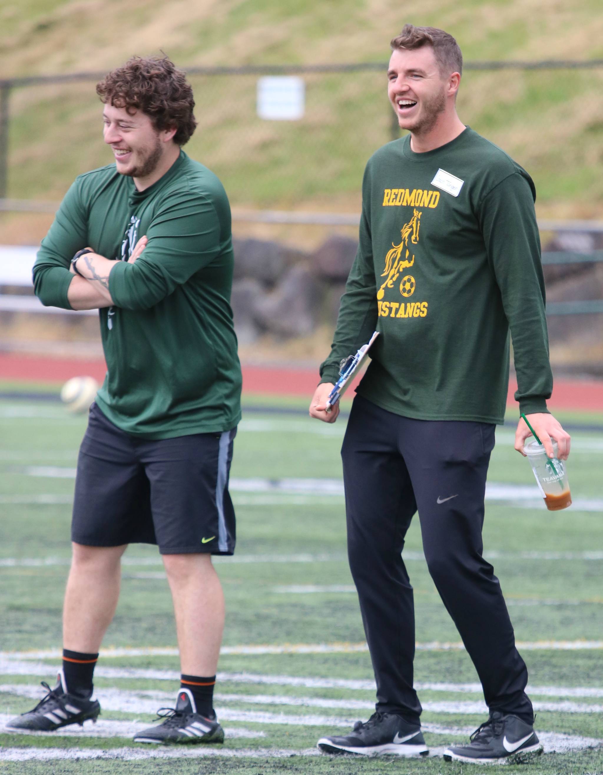 Redmond High coaches Antonio Medina, left, and Trevor Tangen share a laugh at camp. Andy Nystrom /staff photo