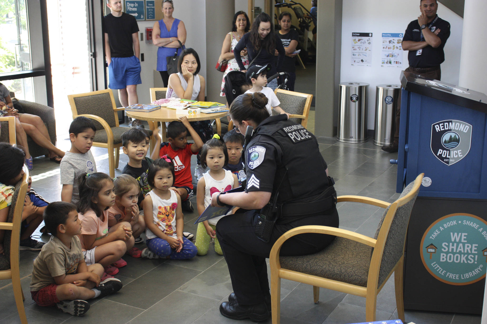 Sergeant Julie Beard reads “Officer Buckle and Gloria,” promoting safety to local children at the Little Free Library opening. Kailan Manandic, Redmond Reporter