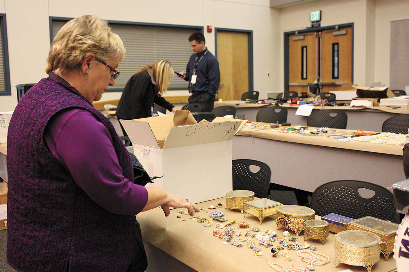 Gail Genereau of Lake Forest Park scours the items recovered from the “Movie Bandits” burglaries in 2012 at the Redmond Police Department as the result of a Pro-Act investigation. She found some of her stolen jewelry. File Photo