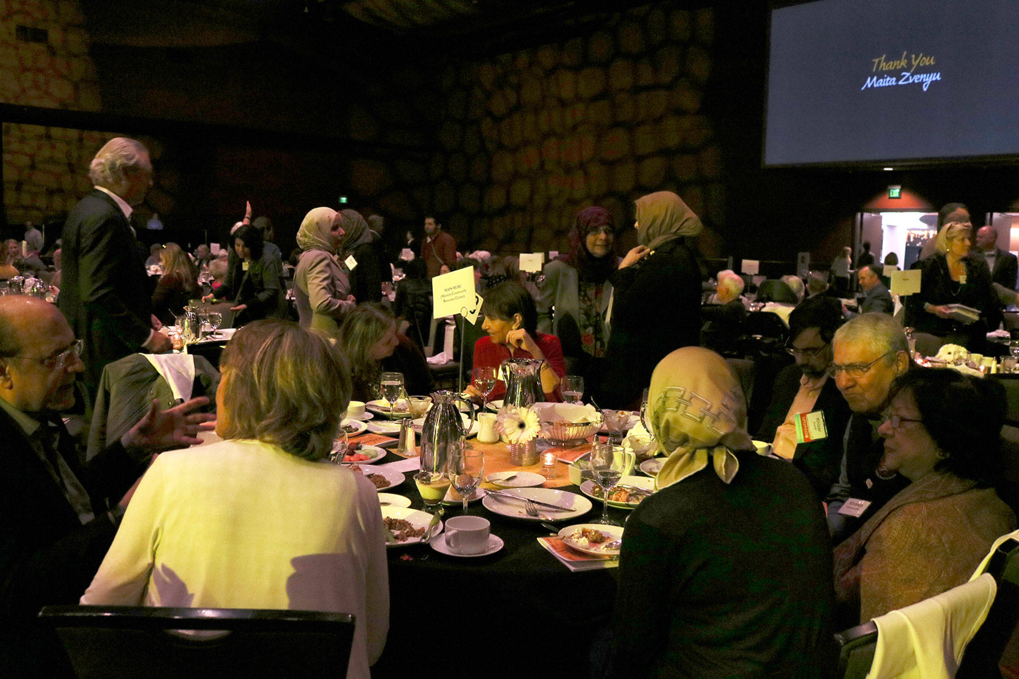Hopelink luncheon attendees at the Muslim Association of Puget Sound (MAPS) table chat at the end of the event. Katie Metzger/staff photo