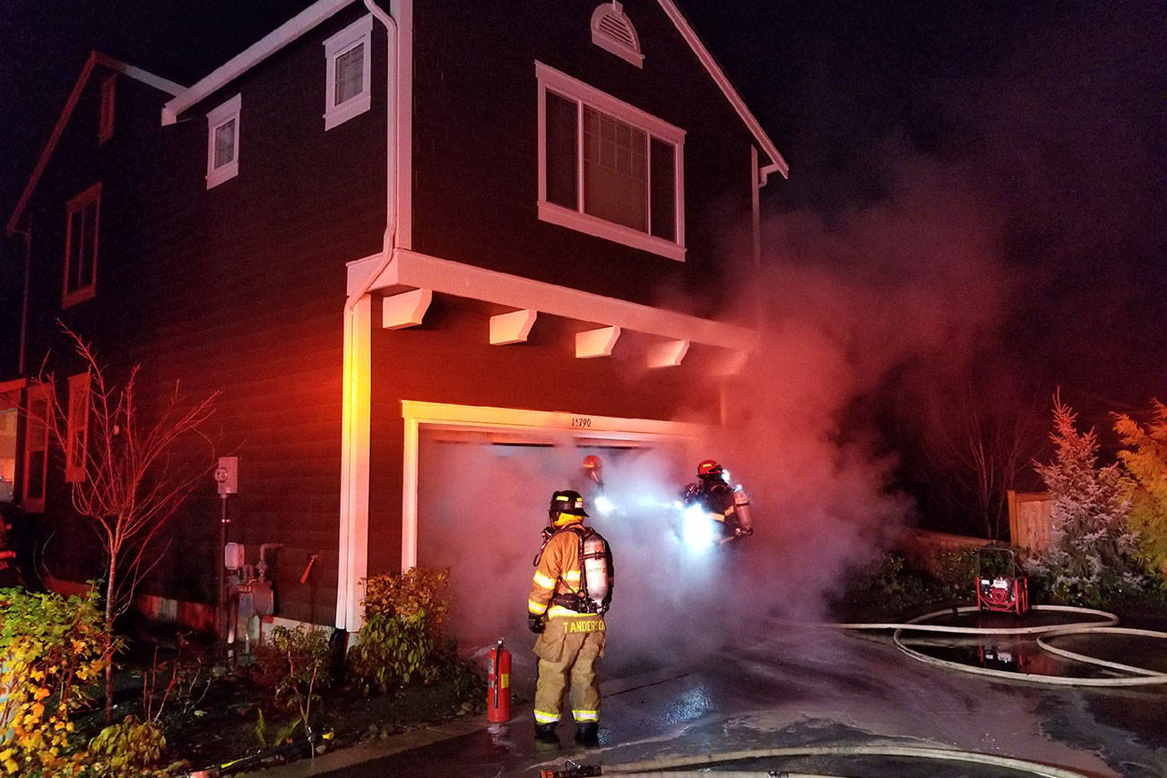 Firefighters extinguish the garage fire in Redmond. The fire would have spread much more without the home’s sprinkler system. Photo courtesy of the city of Redmond