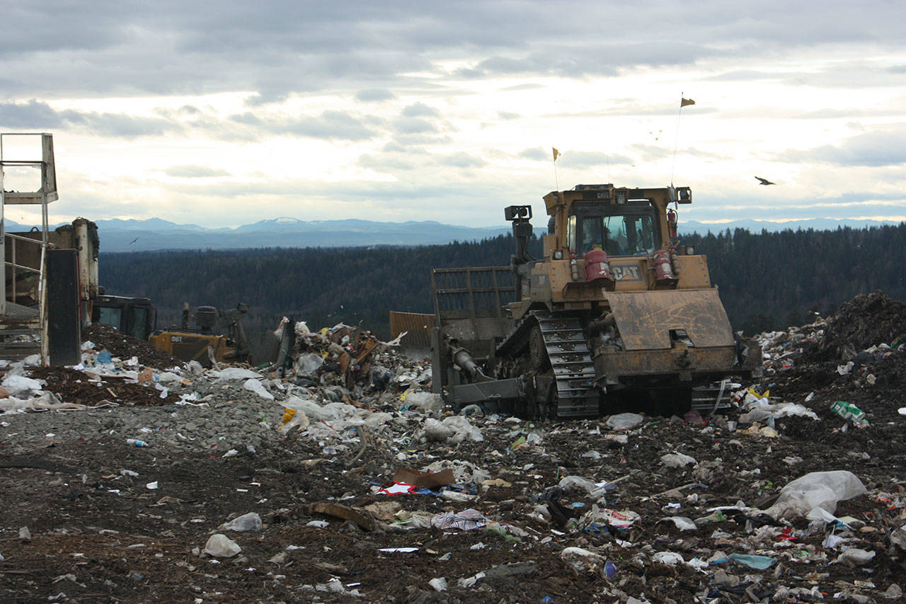 A tractor moves to push trash away from where it was emptied from a cargo trailer atop the Cedar Hills Regional Landfill. An eighth and final section of the landfill is almost ready to come online, extending the life of the landfill through 2028. Aaron Kunkler/staff photo