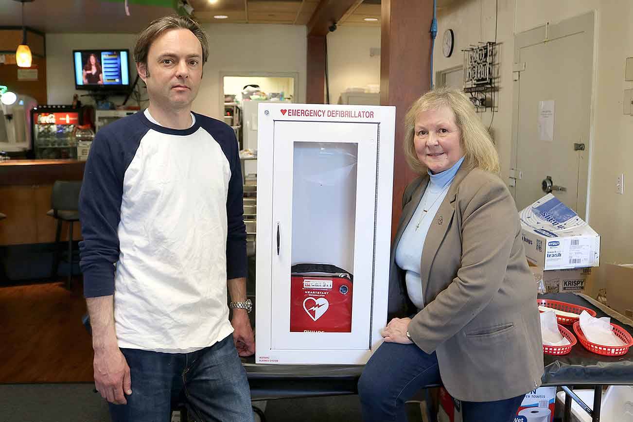 Stephanie Quiroz/staff photo                                 Veterans of Foreign Wars Post 2995 club manager Rob Bailey and lifetime auxiliary member of Post 5694 and guest of the VFW Post 2995 Cecilia Maers with the donated AED and cabinet.