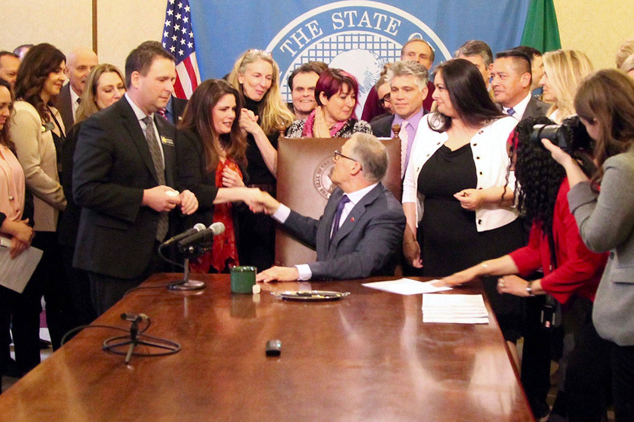 Gov. Jay Inslee shakes hands with Dinah Griffey after signing Senate Bill 5649 on April 19. The law revises the statute of limitations for sex crimes. Photo by Emma Epperly, WNPA Olympia News Bureau