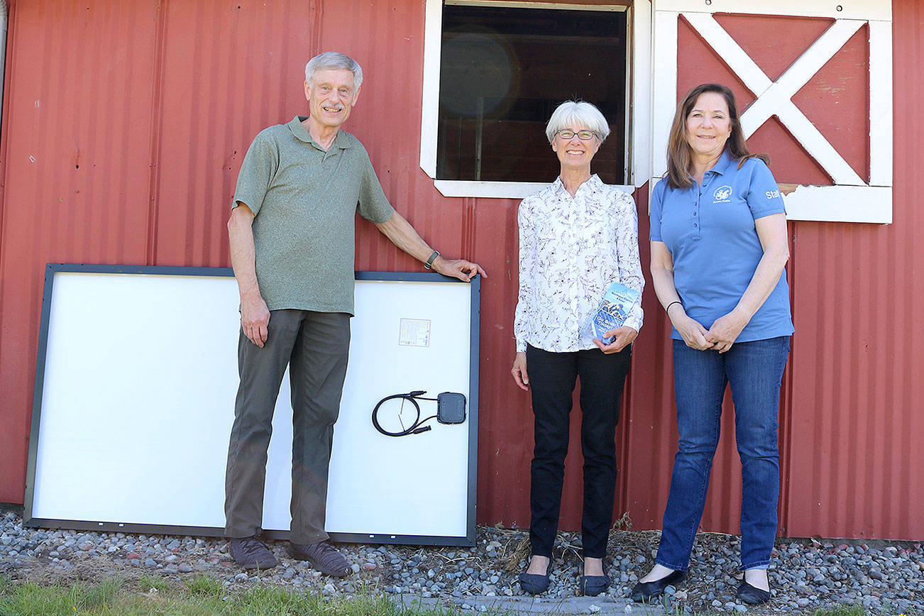 From left: Craig Olson, Joan Schrammeck, and Paula Paula DelGiudice with a solar panel. Stephanie Quiroz/staff photo