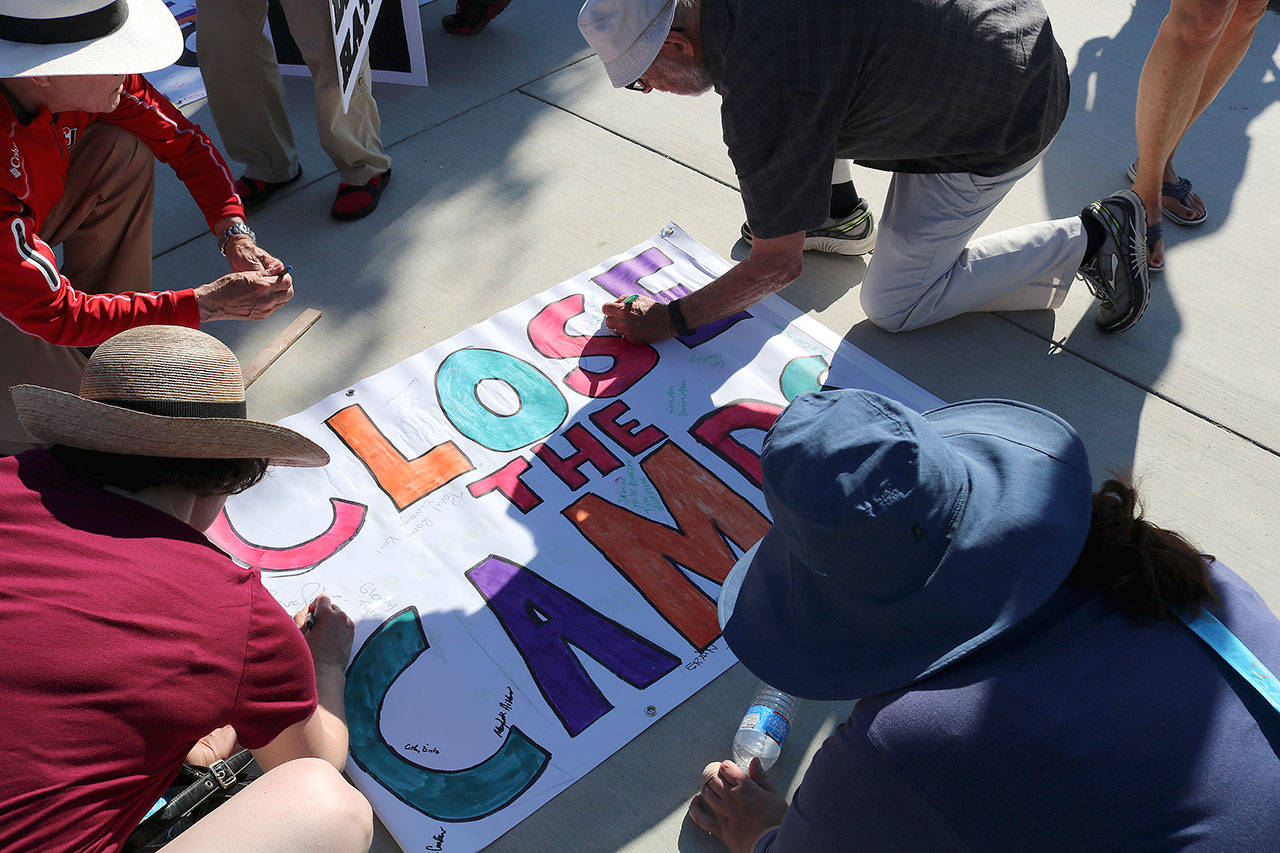 Protestors sign a “Close The Camps” banner that was delivered to the offices of Sen. Patty Murray (D-WA), Sen. Maria Cantewell (D-WA) and Rep. Suzane DelBene (WA-01). Stephanie Quiroz/staff photo