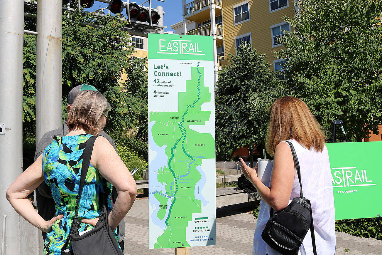 Attendees take a closer look at the new Eastrail logo and tagline, “Let’s Connect” on July 20 in Redmond. Stephanie Quiroz/staff photo