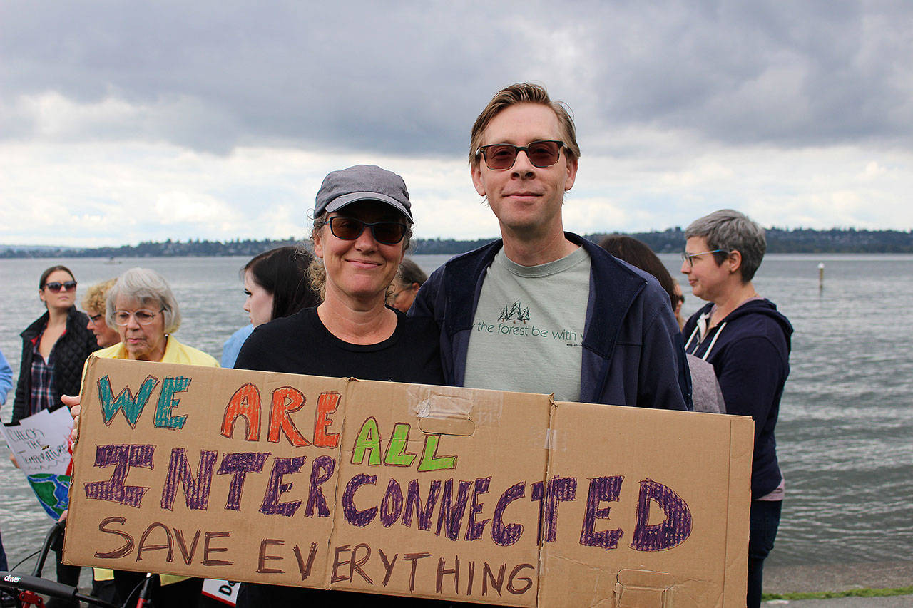Karen Richards and Matt Armstrong held a sign that says “We are all interconnected. Save everything” at Friday’s climate strike. Madison Miller/staff photo