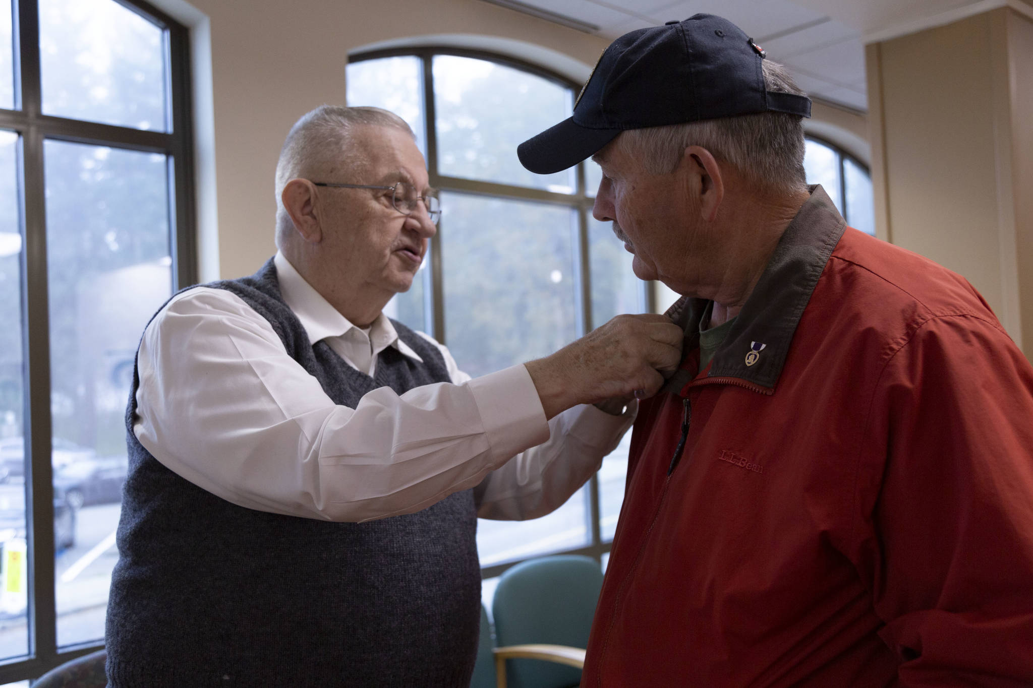 After a quick chat in the waiting room of the American Lake VA Medical Center, Jim Curtis, right, is given a small American flag pin by a fellow veteran. Curtis was there drawing attention to his fundraising efforts. Staff photos / Ashley Hiruko