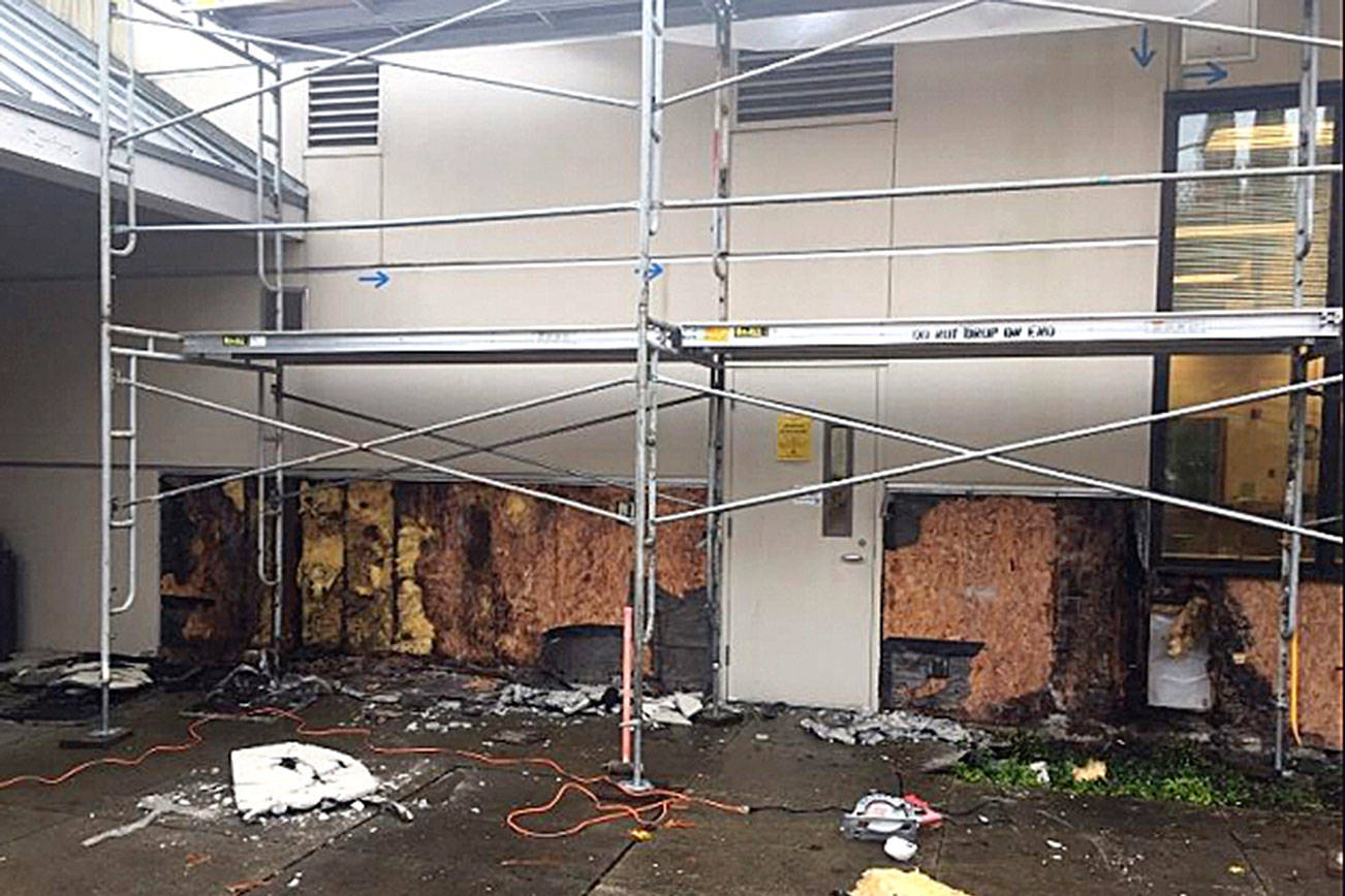 Photo courtesy of the city of Redmond                                 Large scale stucco removal towards the back of the building reveals extensive damage.
