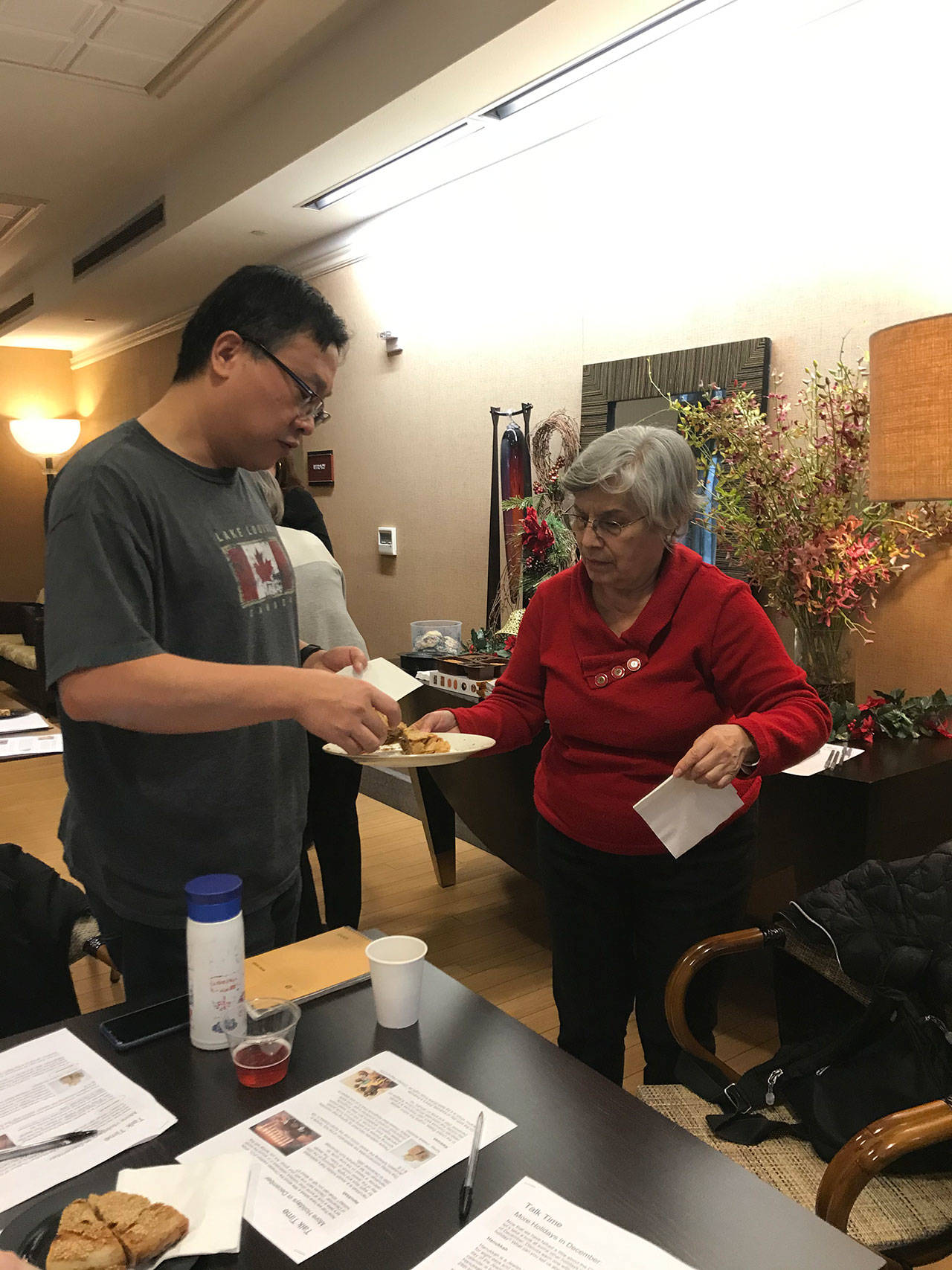 From left, James Yang and Maria Lanz discuss holiday treats during the last Talk Time class before Christmas at Aljoya Mercer Island. Samantha Pak/staff photo