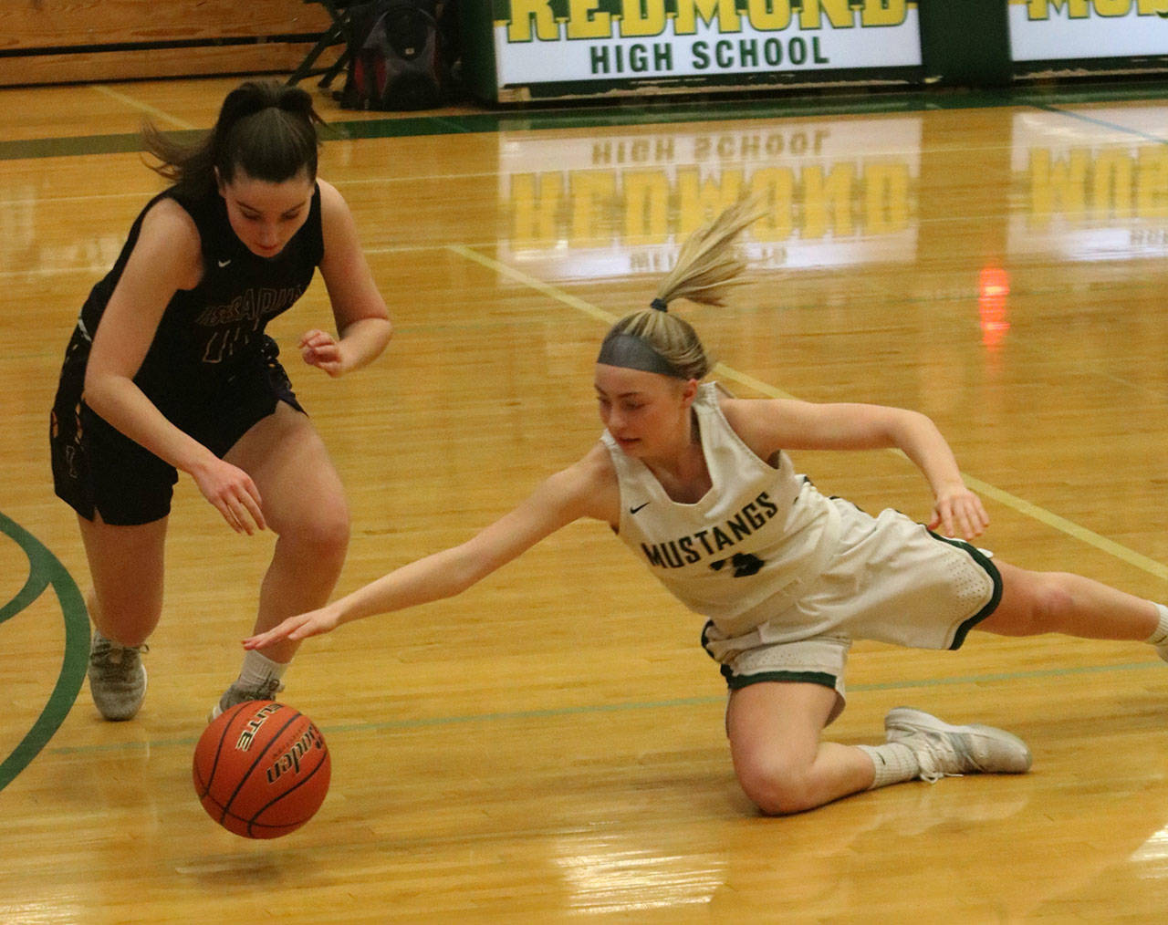 Redmond’s Willow Thom, right, dives for the ball in Tuesday night’s game against Issaquah. Andy Nystrom/ staff photo
