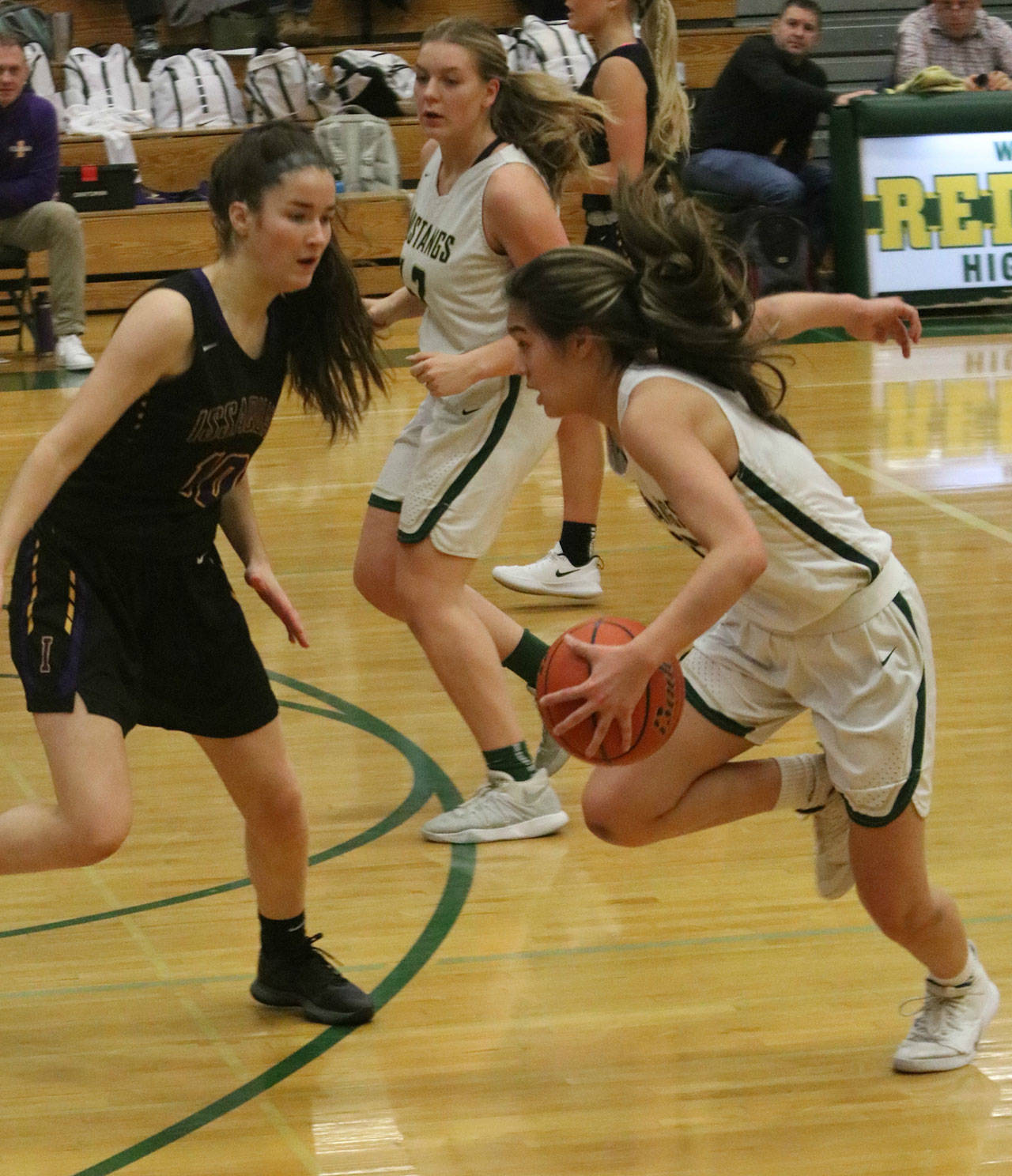 Redmond’s Sami Castanos, right, prepares to attack the hoop against Issaquah. Andy Nystrom/ staff photo
