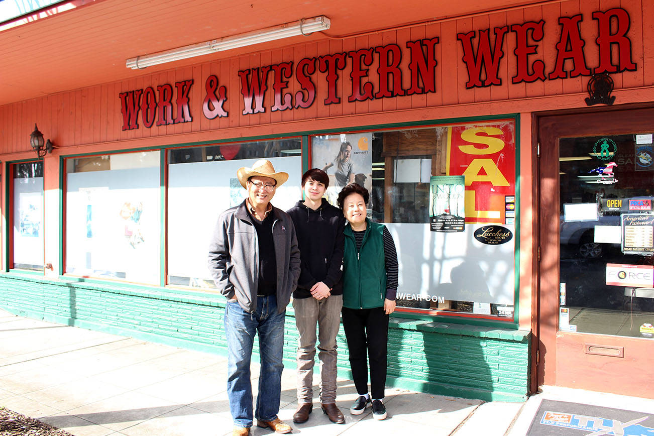 From left, Joe Hong, Marcus Chhong and Sally Hong pose outside of Redmond Work and Western Wear in Redmond. on March 4. Mitchell Atencio/staff photo