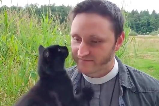 Screenshot of the stray kitten and the Rev. Aaron Burt from the July 12 liturgy video.