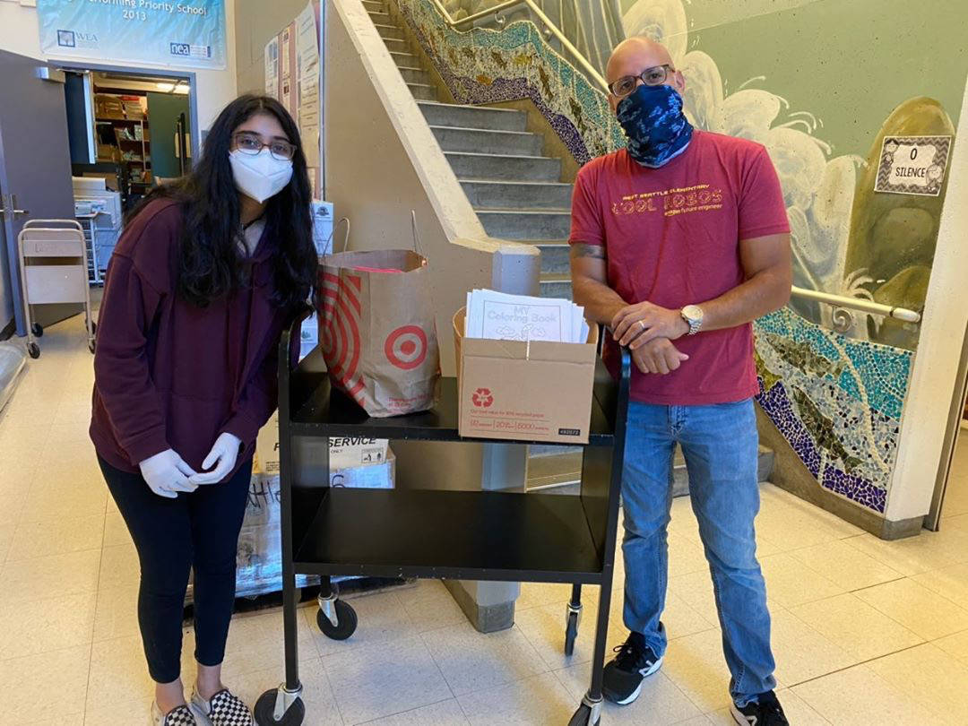 Diya Garg, left, distributes Mighty Crayon recycles crayons and coloring books for Seattle students. Courtesy photo/Diya Garg.