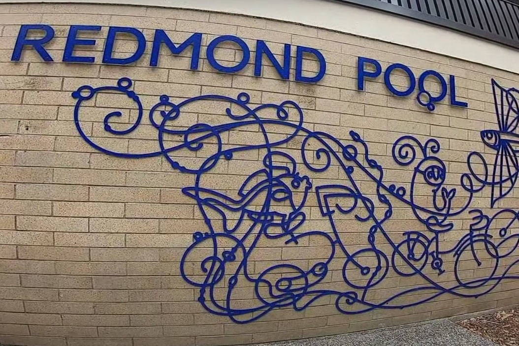 Redmond Pool sign with an art installation entitled "Fish on Bicycles" by Peter Goldlust and Melanie Germond (screenshot from virtual tour video published by City of Redmond)