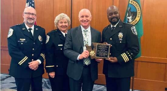 Redmond Police Chief Darrell Lowe (right) accepts award on behalf of the department. (Courtesy of City of Renton)