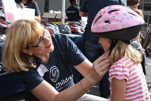 Seattle Children’s Hospital volunteer Cindy Lewis fits a helmet for a young girl at an event in 2012. Free helmets are provided to children across the state through Kohl’s Helmet Safety Program at Seattle Children’s Hospital. Tomorrow’s event will take place from 10 a.m. to 1 p.m. at Kohl’s in Redmond.