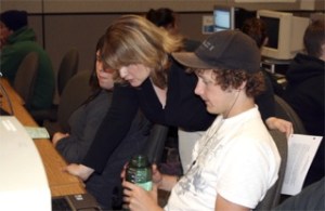 Redmond High School Personal Finance teacher Jennifer Harris checks the research of senior Luke Wylie as students weigh the pros and cons of buying new or used cars.