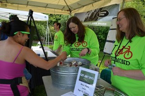 Senior planner Kim Dietz (right) and other City of Redmond employees speak with community members at Bike Bash about the city's new Get Around campaign.