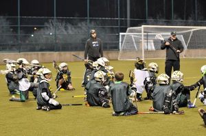 Players on the Redmond Lacrosse Club 5/6 team listen to the coaches explain the season.