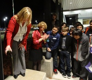 LWSD Superintendent Dr. Traci Pierce (left) christens the new Stella Schola Middle School building with apple cider.