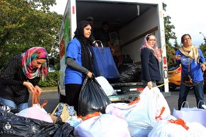 Volunteers work to load bags of donated clothing onto a truck. The clothes will go to Syrian refugees in Jordan and other countries.