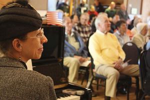 Sophisticated Swing band pianist Terry Turner takes a break and listens intently to a speaker this afternoon at the Redmond Senior Center's Veterans Celebration. The Redmond Senior Chorus also performed in front of about 200 people