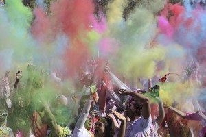 People toss colors in the air at today's Festival of Color at the Downtown Park in Redmond. The event celebrated Holi