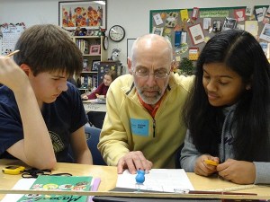 Rep. Larry Springer (center) works on a physics assignment with two students at Stella Schola Middle School in Redmond.