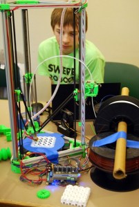 Webster Winters watches his mini Kossel 3D printer generate a gyroid. He built the project with is father.