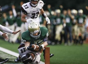 Redmond High running back Bryce Steckler stretches to reach the goal line and scores his third touchdown of the first half against Mercer Island High on Friday night. Redmond won