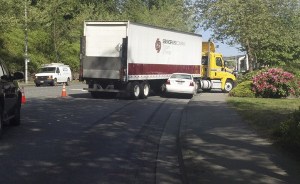 The semi-truck was in the process of making a right turn off Redmond Way when a car hit the truck and became wedged underneath the trailer.