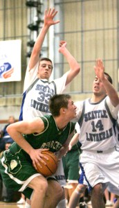 Bear Creek's Lucas Fernandez (No. 33) is guarded by Seattle Lutheran's Brian Simmons (No. 33) and Beau Severson (No. 14) as he heads to the basket during a game at Seattle Lutheran High School on Fri.