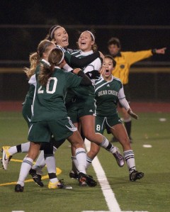 Bear Creek players mob senior Morgan Rial (second from right) after she scored the game-winning goal in the 77th minute of last night's Tri-District soccer game