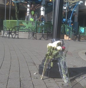 Flowers are placed near the area of Redmond Town Center where a 2-year-old girl was struck by a car and killed on Wednesday evening. The playground where she was playing is in the background.