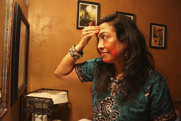 Latha Sambamurti applies colored powder on her face to show what will be used during the Festival of Color. The festival is similar to India’s Holi festival