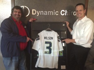 Dynamic Chiros of Redmond held a raffle from Jan. 1 to Feb. 14 for a signed Russell Wilson jersey. George Nassar (left) was the winner and he is joined by Dr. Mark Thompson.