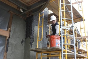 A worker applies stucco to the side of the building that will be BJ's Restaurant and Brewhouse in Redmond Town Center.