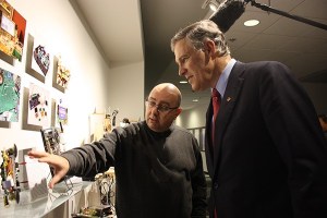 DigiPen Institute of Technology President Claude Comair (left) shows Washington Gov. Jay Inslee some of the school's student work while touring the campus.