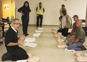 Mike Hilley (left) instructs residents from Tent City 4 at St. Jude Parish in Redmond in CPR Thursday evening. Hilley also answered residents' medical questions.
