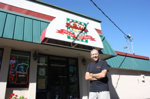 Frank Curtiss stands in front of his restaurant