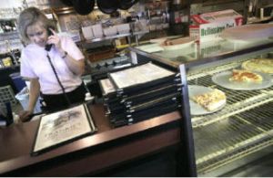 Julie Criss answers the phone while working at Frankie’s Pizza & Pasta. Criss also works as a realtor