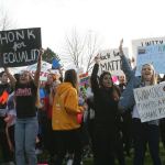 Students from Lake Washington High School, which also includes Redmond students, wave signs during today&rsquo;s walkout to protest presidential election results. Catherine Krummey, Reporter Newspapers